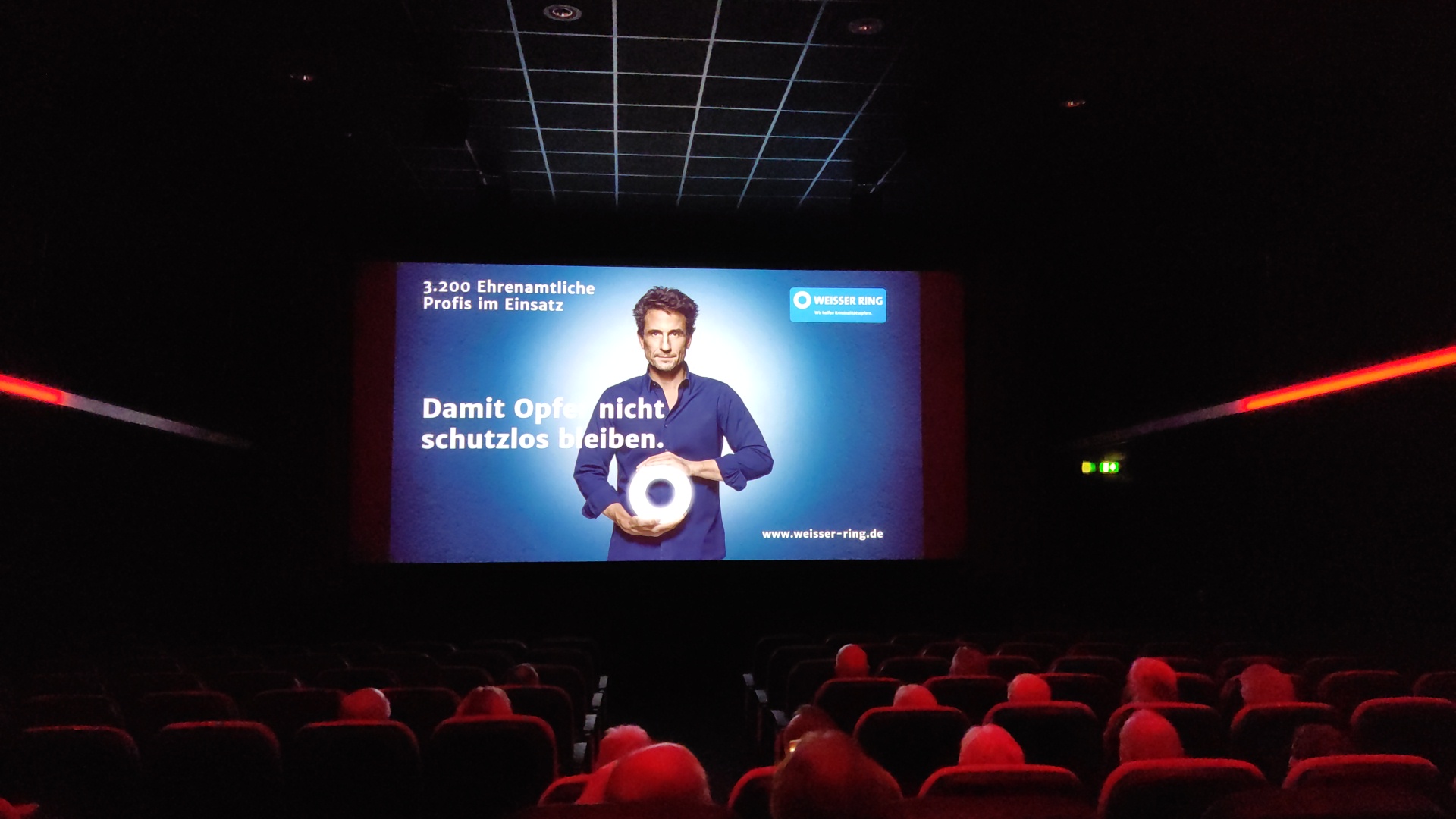 Kinosaal, Werbespot des Weissen Rings mit dem Schauspieler Oliver Mommsen wird gezeigtn 